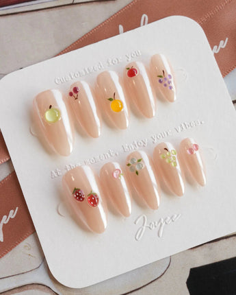 Mini Fruit close-up of miniature fruit charms on glossy nude nails
