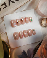 Mini Noel press-on nails in extra short coffin shape — nude cat eye christmas icons