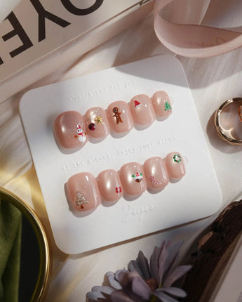 Mini Noel press-on nails in extra short squoval shape — nude cat eye christmas icons