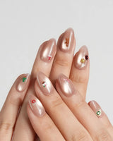 Mini Noel nail art close-up showing nude cat eye christmas icons details