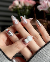 Miss Miffy short almond press-on nails with nude base, silver metallic accents and 3D rabbit