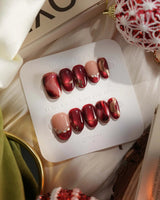 Molten Rouge press-on nails with molten red cat-eye shimmer, gold details and crystal accents