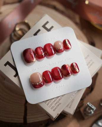 Molten Rouge extra short squoval press-on nails with red cat-eye and gold outline accents