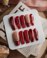 Molten Rouge long coffin press-on nails with deep red cat-eye and crystal accents