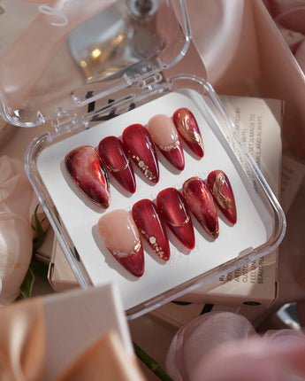 Molten Rouge medium stiletto press-on nails with deep red cat-eye and gold crystal accents