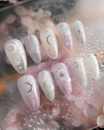 Moonrest handmade press-on nails featuring Pink and white ombre with glitter, silver stars, and a moon