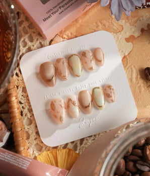 Earthy glow handmade press-on nails featuring nude peach gold foil leaf accents