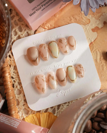 Earthy glow handmade press-on nails featuring nude peach gold foil leaf accents