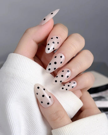 Dot Noir press-on nails with nude and black contrast and retro polka dot design