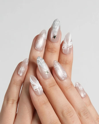 Snowfall handmade press-on nails featuring pearl nude cat eye snowflake bow silver glitter soft sheen