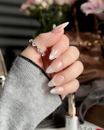 Dew Sparkle in short almond shape with glossy nude French tips and pearl-like accents