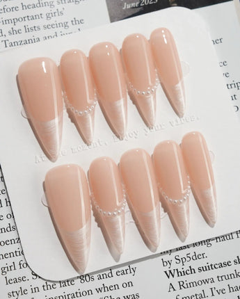 Dew Sparkle in long stiletto shape with nude French tips, pearl accents, and silk shine