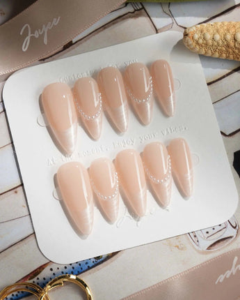 Dew Sparkle in medium stiletto shape with nude French tips and shimmering pearl detail