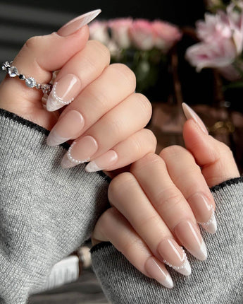 Dew Sparkle short almond press-ons with nude base, pearl accents, and glossy French tips