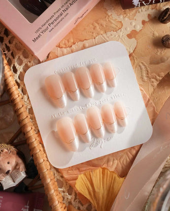 Close-up of Your Glow nails with nude cat-eye shine, French tips, and gold wire detail