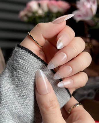 Your Glow nude French tip nails with soft cat-eye shimmer and delicate gold wire accents