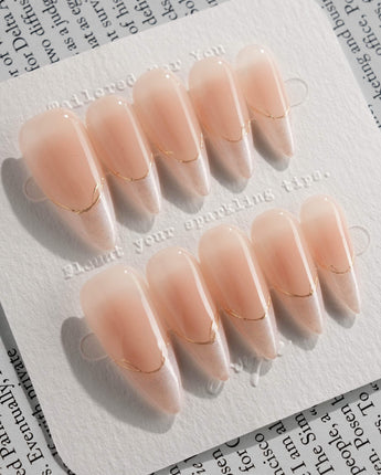 Your Glow in medium stiletto shape with nude cat-eye French design and gold linework
