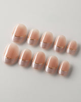 Your Glow in extra short oval shape with nude French tips and soft metallic shimmer