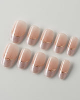 Your Glow in short oval shape with soft nude French tips and fine metallic gold linework
