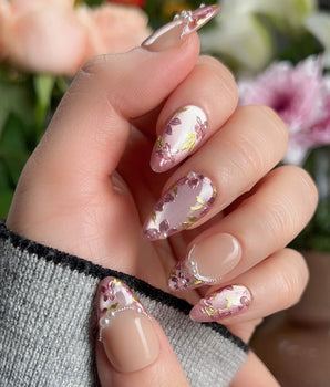 Nude pink nails with hand-painted sakura petals and pearl French line	