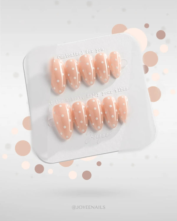 Nude press-on nails with white polka dots