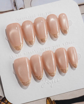 Nude Spark press-on nails in short almond shape — Premium Champagne Cat Eye, Irregular French Metal Outlines.