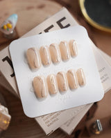 Oat Latte press-on nails in short coffin shape — Sheer Nude Skin, Minimalist Silver Glitter Swirls.
