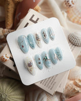 Ocean Heart muted grey-blue nails with metallic fish, coral and pearl bubbles