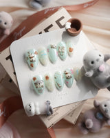 Otter Momo extra short almond nails with 3D otters on mint water-ripple gel