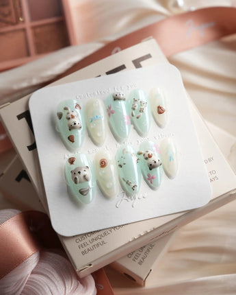 Otter Momo medium almond nails with otter nail art, petals, and seashell details