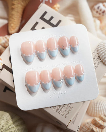 Oyster Blue extra short almond nails with nude base, blue French tips, and pearl smile line
