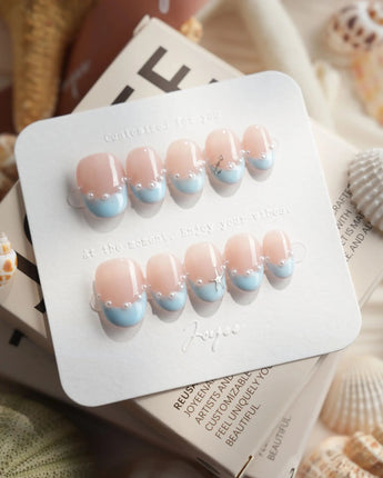 Oyster Blue extra short oval nails with baby-blue French tips and pearl accents