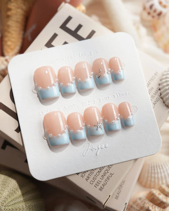 Oyster Blue short square nails with pearl-lined French tips and silver starfish charm