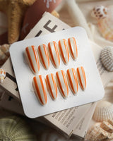 Parasol medium stiletto press-on nails with orange and cream beach-stripe art