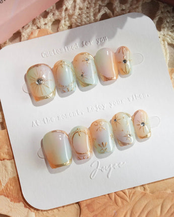 Pastel Relic press-ons with sheer milky shimmer, gold line details, and soft pastel glow
