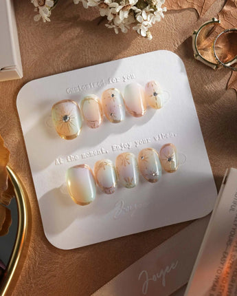 Pastel Relic nails with champagne-toned gradient, fine gold accents, and glossy finish