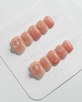 Peach Dew glossy almond nails with peach-colored fruit sculpture and water droplets