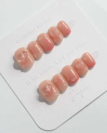Peach Dew glossy almond nails with peach-colored fruit sculpture and water droplets
