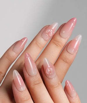 Peach Dew medium almond nails with soft peach glow and translucent fruit accents