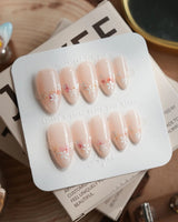Petal Press press-on nails in medium almond shape — Warm Creamy Skin Tone, Hand-painted Florals & glitter Shimmer.
