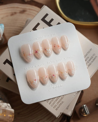 Petal Press press-on nails in extra short almond shape — Warm Creamy Skin Tone, Hand-painted Florals & glitter Shimmer.