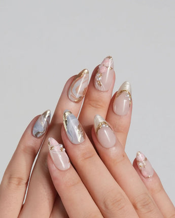 Vintage Mist press-on nails with soft marble texture, gold foil details and pearly accents