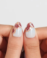Pink Grapefruit glossy citrus press-on nails with warm peel details on icy blue