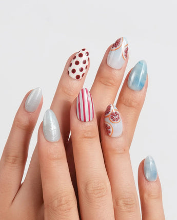 Pink Grapefruit icy blue press-on nails with brown polka dots and citrus details