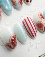 Pink Grapefruit press-on nails with grapefruit slices and red stripe accents