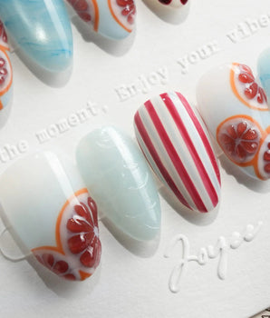 Pink Grapefruit press-on nails with grapefruit slices and red stripe accents