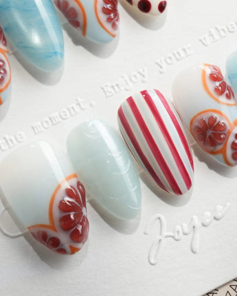 Pink Grapefruit press-on nails with grapefruit slices and red stripe accents