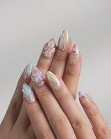 Sunbathing video showing iridescent pastel nails with oversized florals and shells