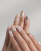 Golden Bay video showing pearly white shell nails with gold wire floral accents