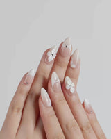 Ceramic nail art close-up showing Classic Nude Pink Ombré, 3D White Florals & Minimalist Rhinestones. details
